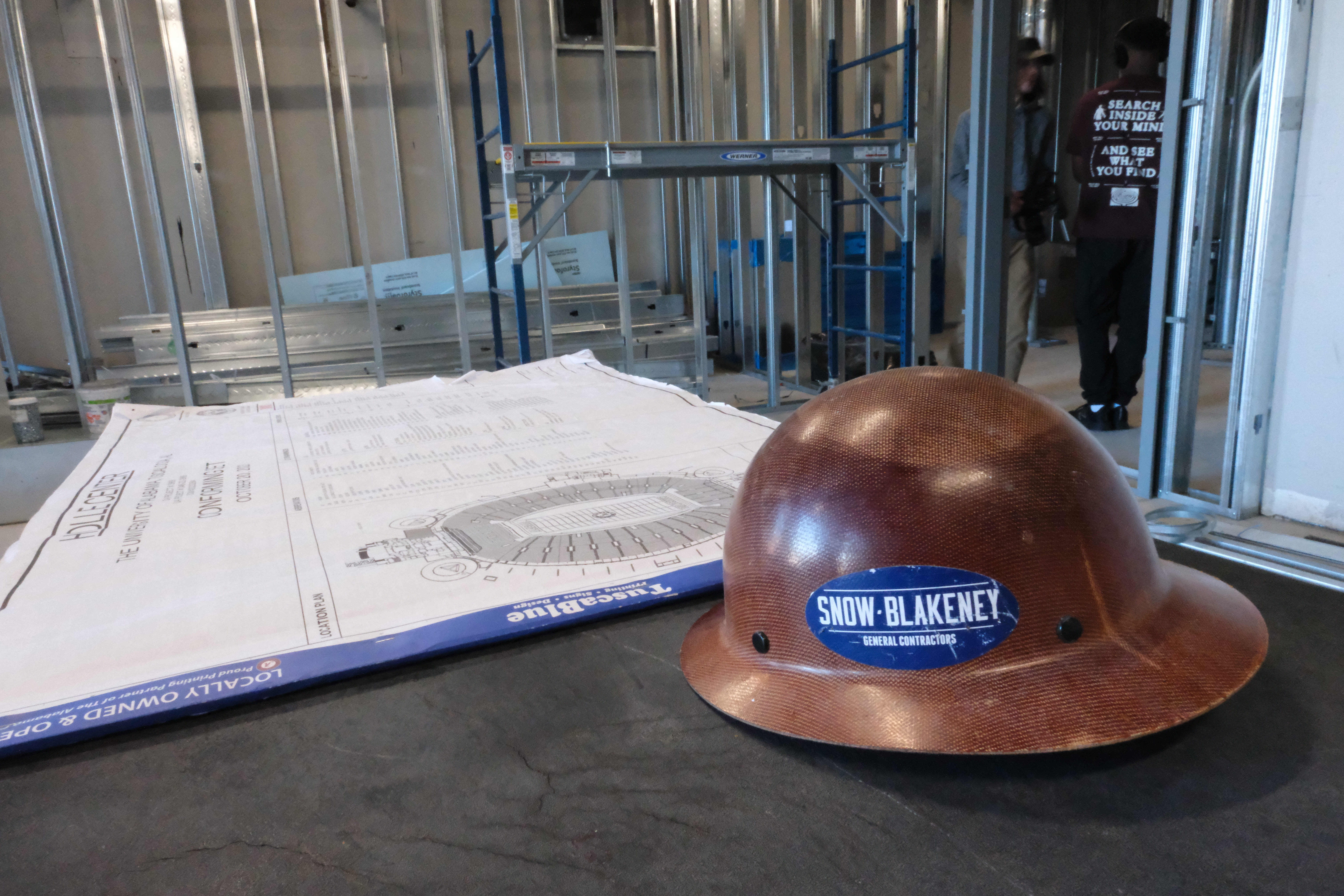 A hard hat in front of the Holle Center blueprints