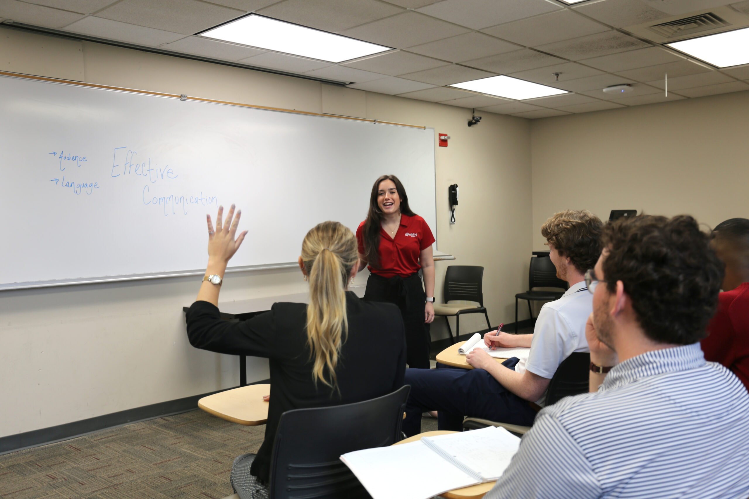 A classroom of students learn about public speaking from a Speaking Studio consultant.