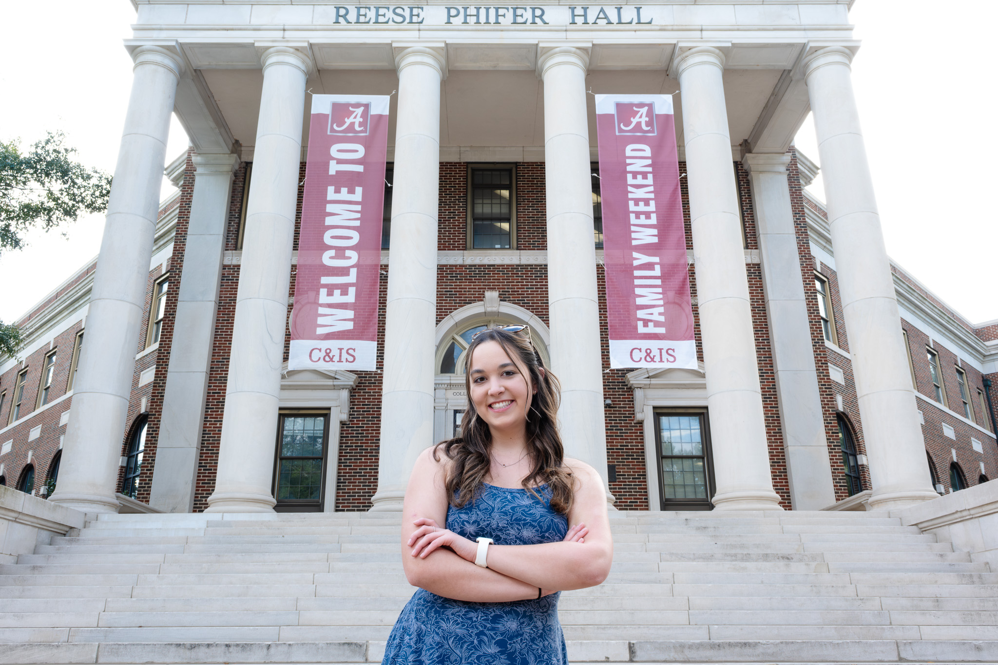 Kat Stanek in front of Family Weekend banners outside Reese Phifer Hall.