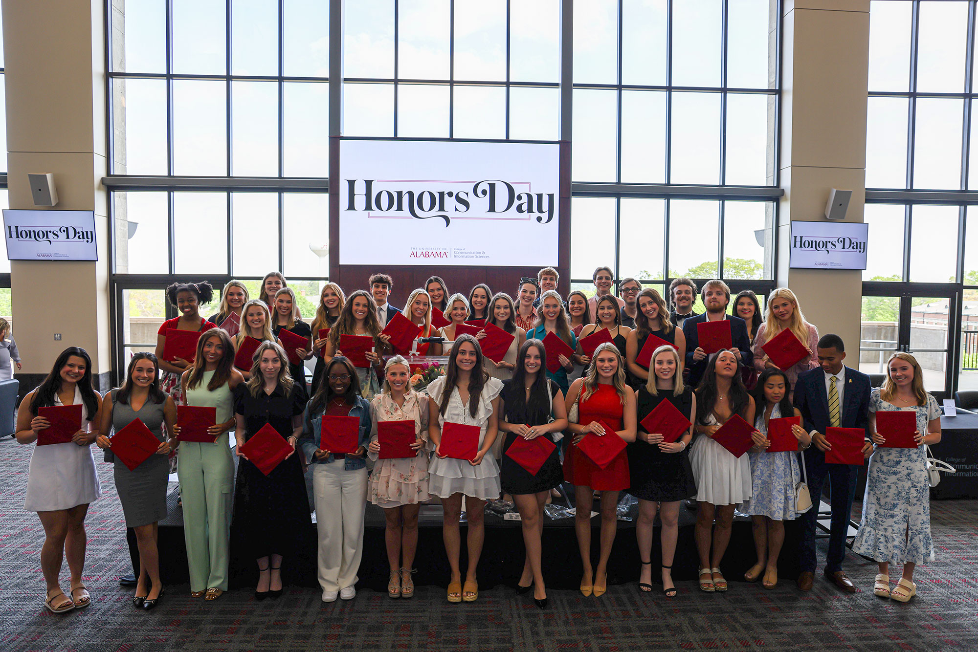 Honors Day Red Cap winners pose for a photo on the stage in front of the Honors Day sign.